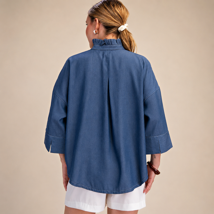 Person wearing a blue shirt and white shorts on a beige background