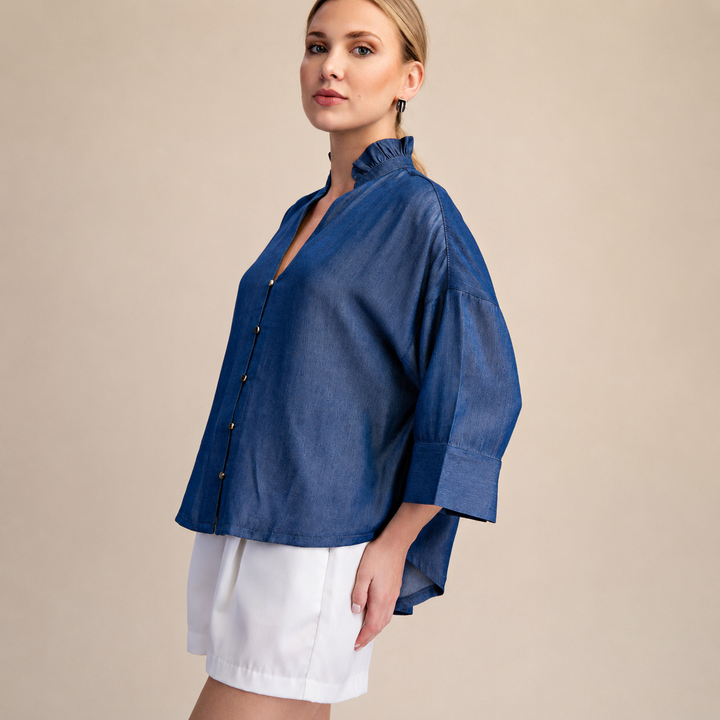 Woman wearing a blue shirt and white shorts on a beige background