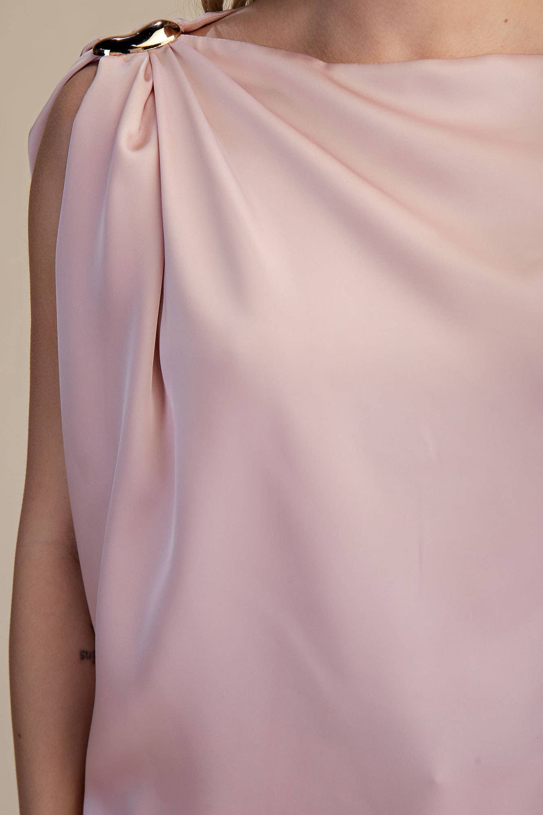 Close-up of a pink satin top with a plain background