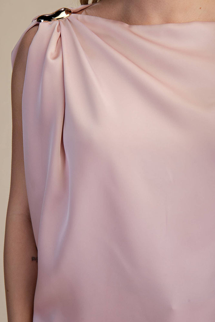 Close-up of a pink satin top with a plain background