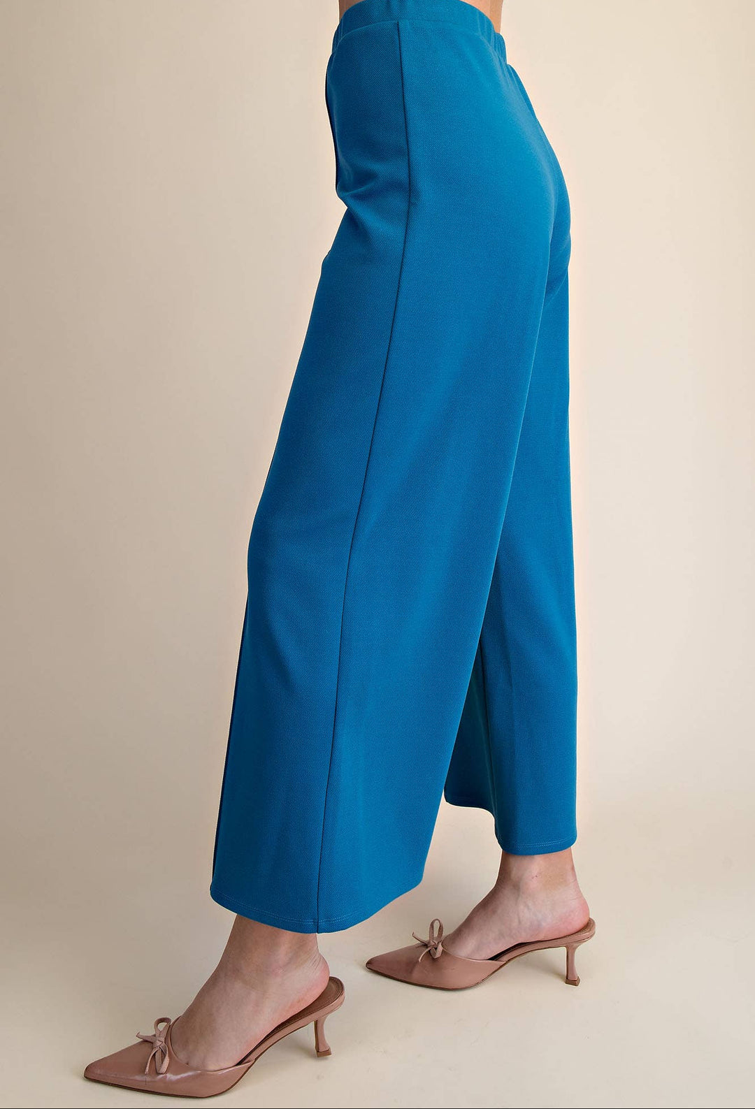 Blue pants worn by a person on a beige background