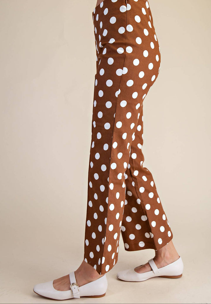 Brown pants with white polka dots worn by a person on a beige background