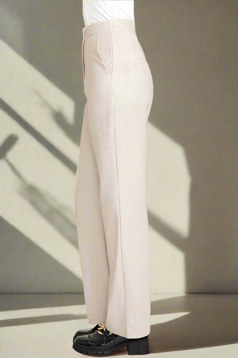 Beige pants worn by a person on a white background