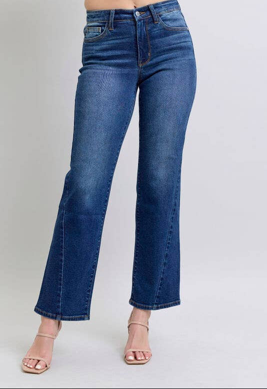 Blue jeans worn by a person on a plain background