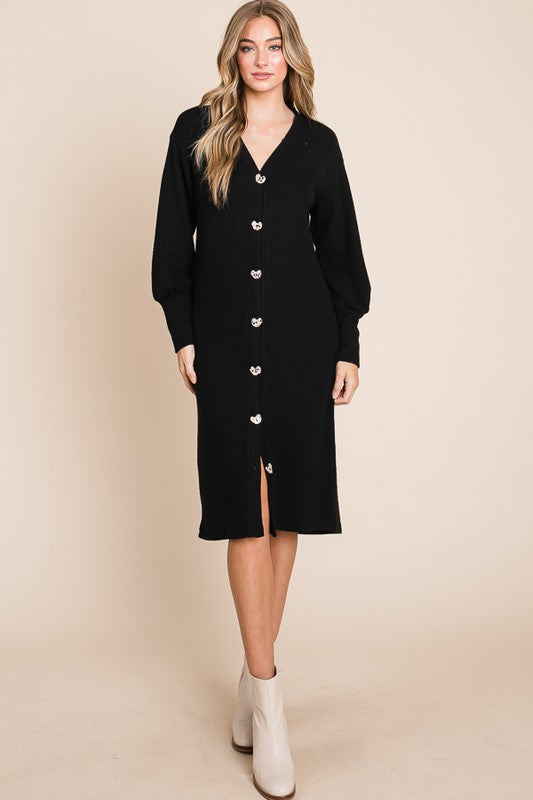 Woman wearing a black cardigan dress with a beige background