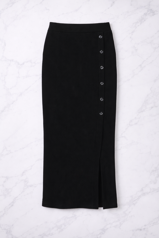 Black button-up skirt on a white quilted surface
