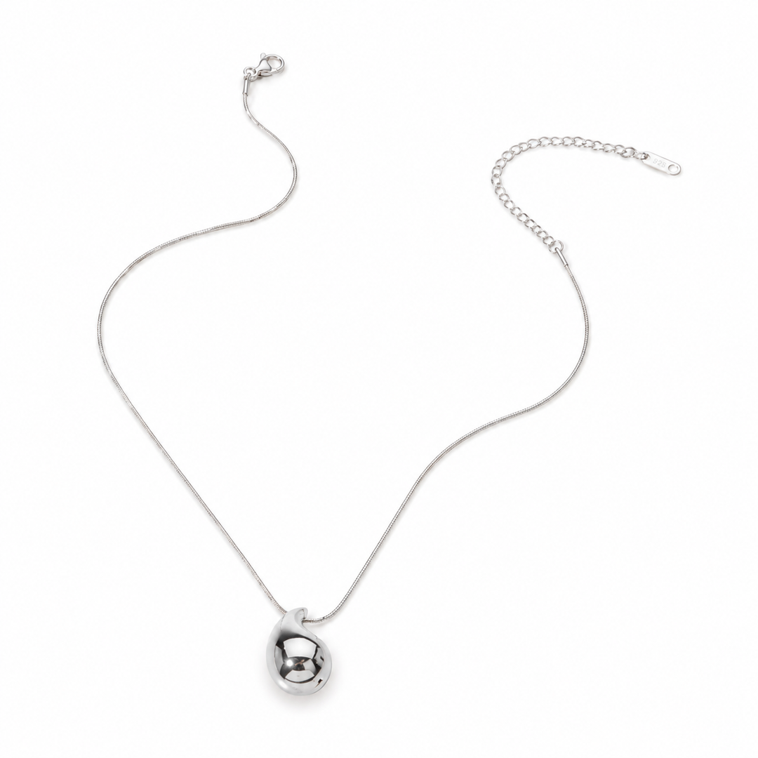 Silver necklace with a small round pendant on a white background