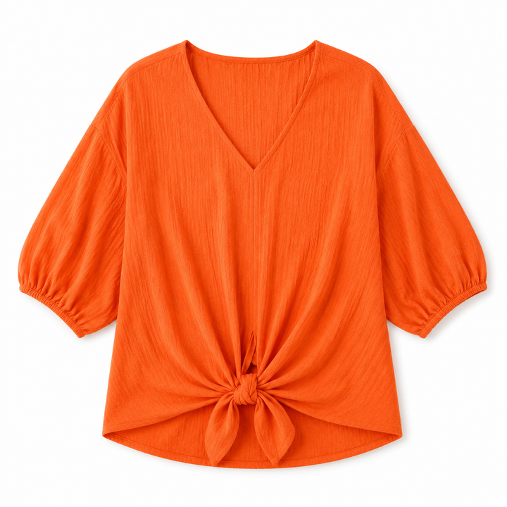 Bright orange crinkle-textured blouse with a V-neckline, balloon sleeves, and a front knot detail at the hem, shown on a plain white background.
