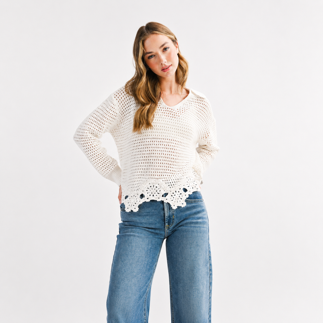 Woman wearing a white crochet top and blue jeans on a white background