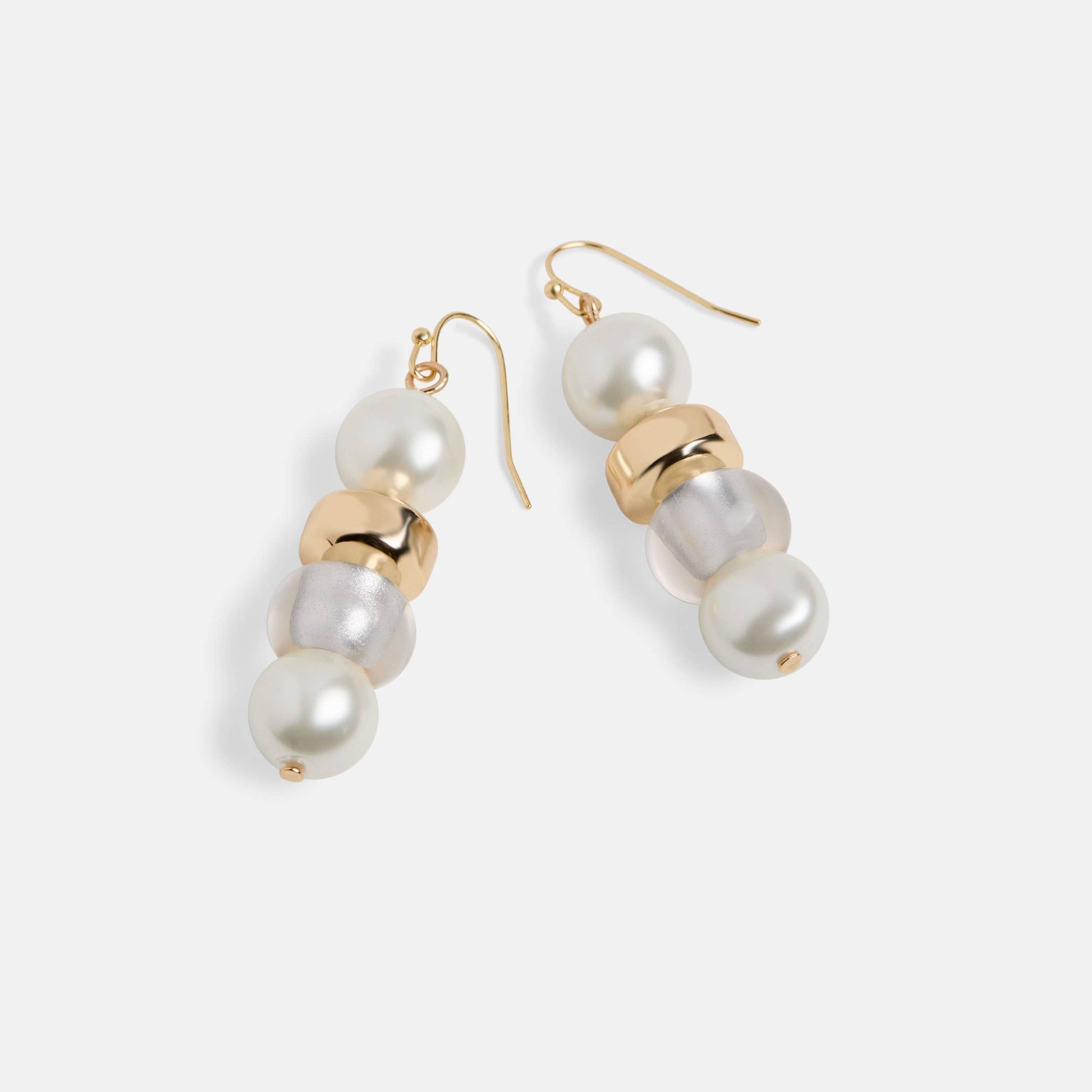 Pair of pearl and gold drop earrings on a light gray background