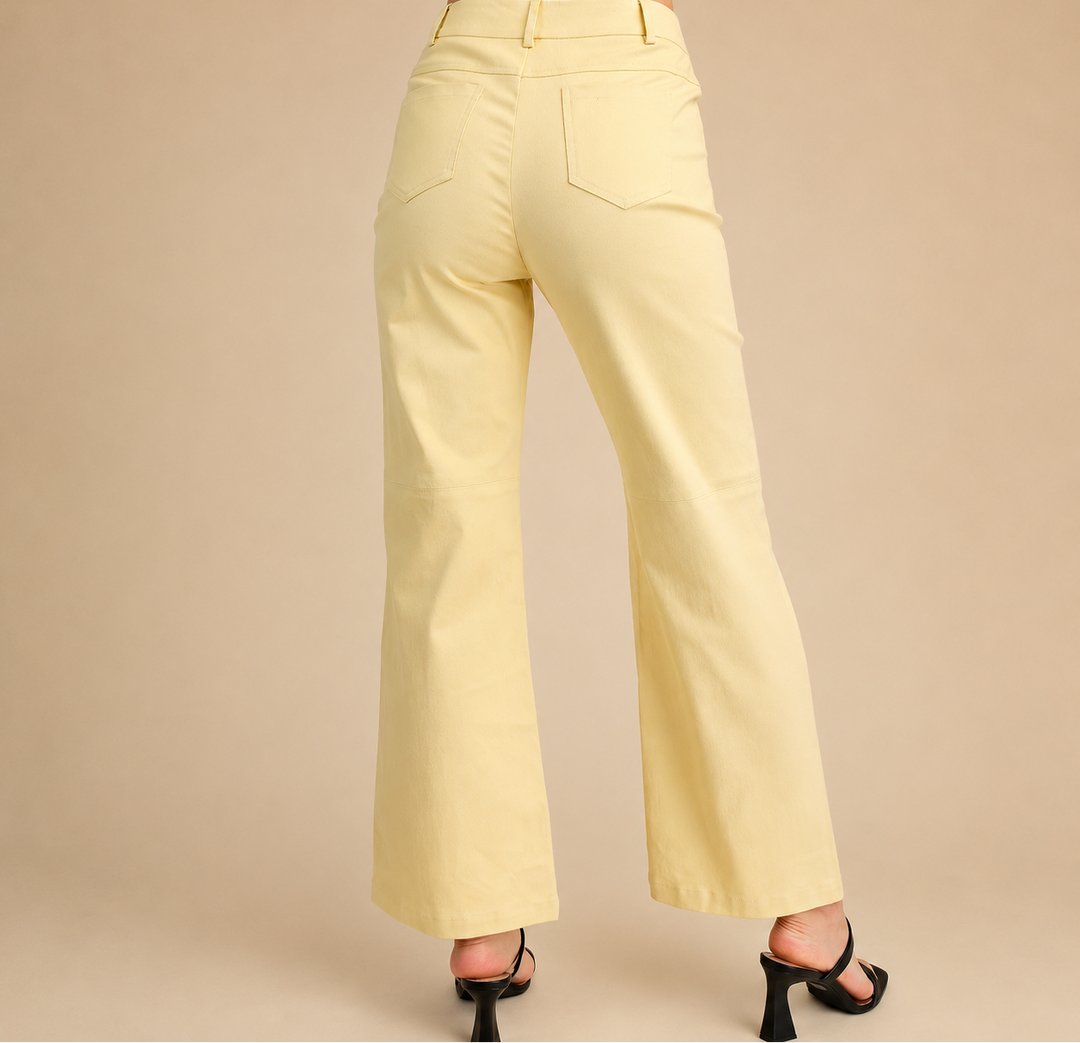 Light yellow pants worn by a person on a beige background